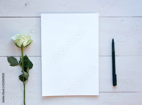 Fototapeta Romantic mood mock up for your text and design, top view, flat lay, notepad with white rose at rustic wooden background. Blank greeting card or illustration sheet, copy past.