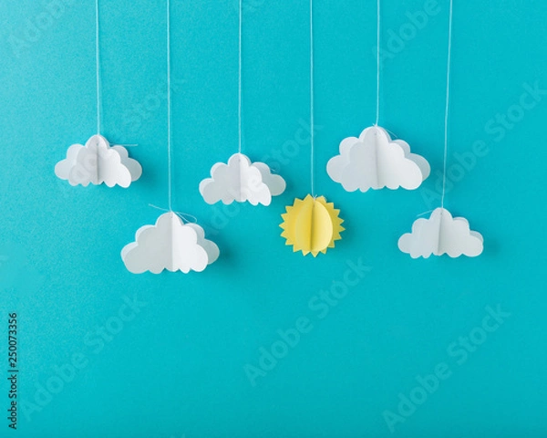 Fototapeta Blue background paper with white clouds on a string, minimalism
