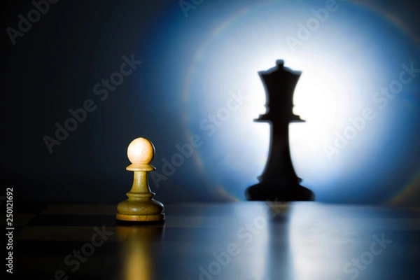 Obraz A pawn on a chessboard looks at its shadow of the future queen