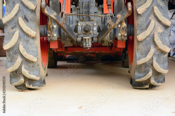 Obraz the behind of orange tractor with big tyre and metal peripheral kit