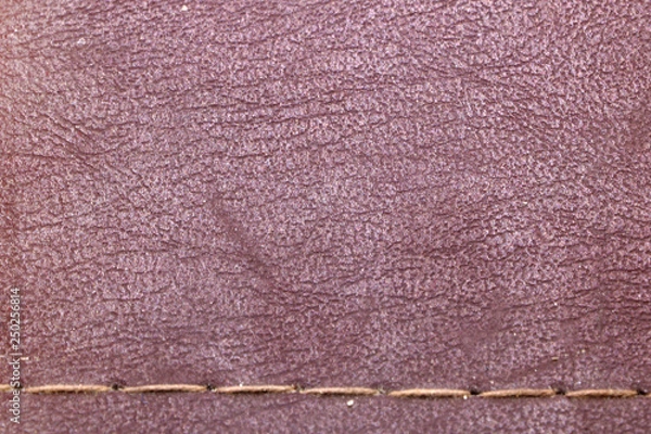 Fototapeta texture of red old leather with a seam of thread
