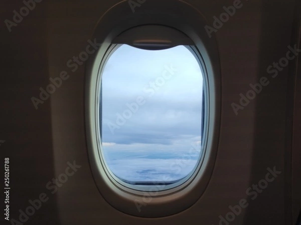 Fototapeta Airplane window with sky clouds view.