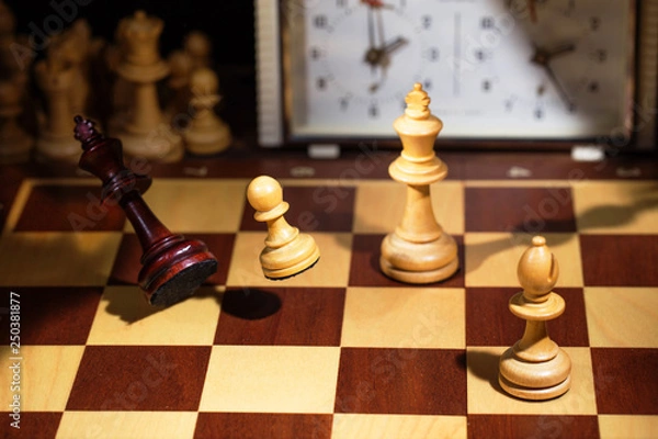 Obraz White's victory on the chessboard. The king fell.Strategy, victory, intelligence.The pawn attacks the king. Shot in motion. Flying figures.
