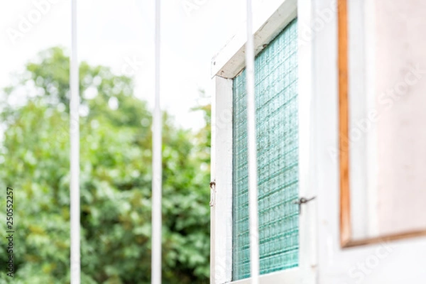 Fototapeta Abstract closeup of bars in open window during summer in country house for anti-theft