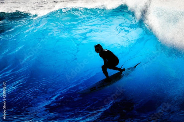 Fototapeta Sylwetka surfer na dużych błękitnych falach na wyspie Madera w Portugalii, popularnym miejscu wśród miłośników surfingu