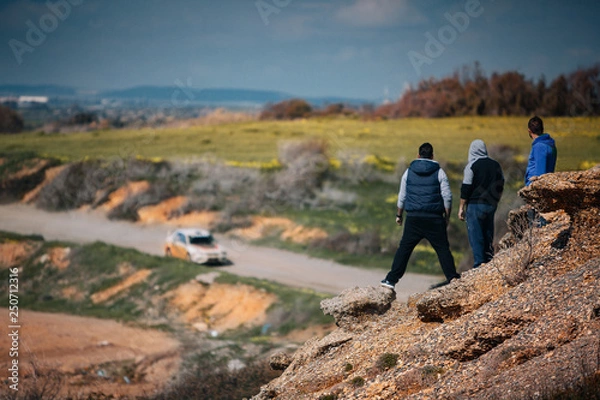 Fototapeta Spectators watching rally race from top ot the rock