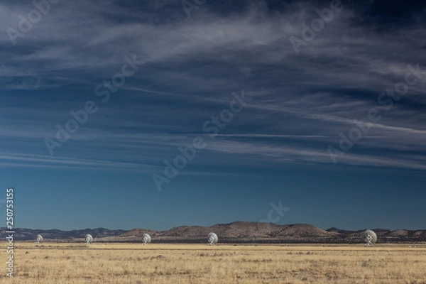 Obraz Very Large Array line of radio astronomy observatory telescopes in the New Mexico desert, copy space in blue sky, horizontal aspect