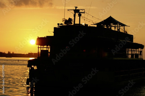 Fototapeta sunset behind boat