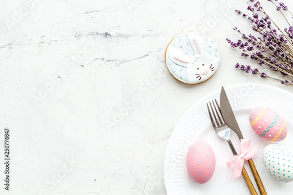 Obraz Easter table setting. Tableware and painted eggs on white background top view space for text