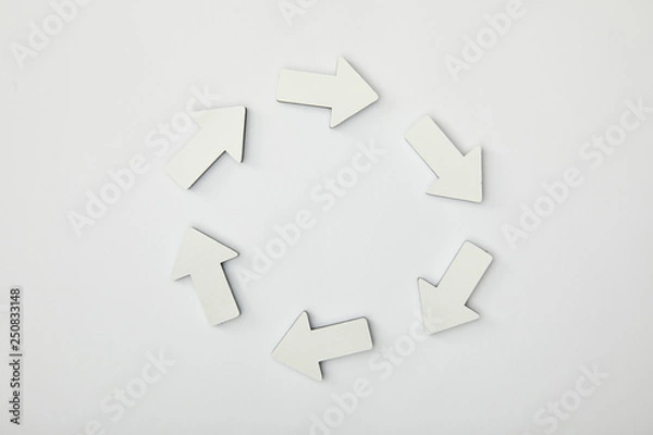 Fototapeta top view of white arrows in circle on grey background