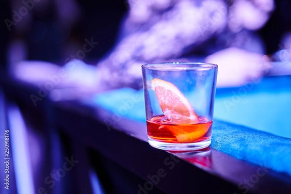 Fototapeta Glass with alcoholic refreshing on a bar table