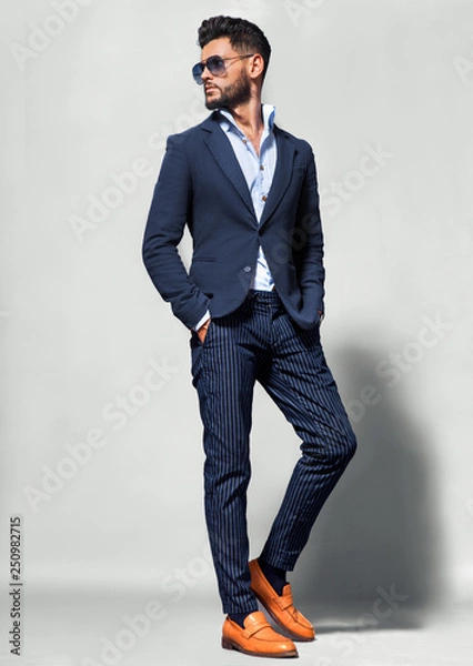 Obraz Elegancki młody przystojny mężczyzna w garniturze w okularach. Studio portret mody.
