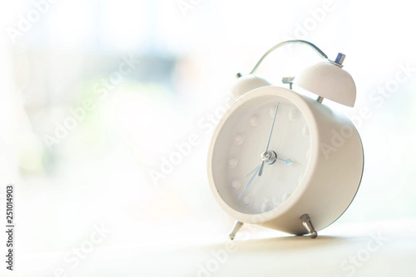Obraz White alarm clock placed on a wooden table and to decorate the house