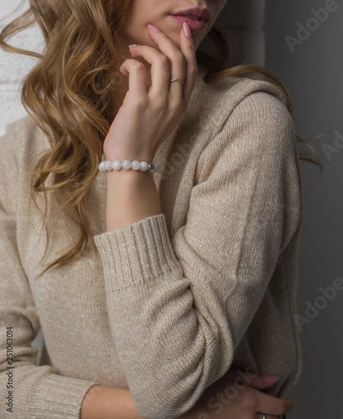 Fototapeta  bracelet made of moonstoneis on the hand, on the arm is a bracelet made of white stones.