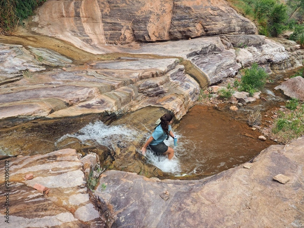 Fototapeta Young woman enjoys some downtime in Hermit Creek during a multi-day backpacking expedition on the Hermit Loop in Grand Canyon National Park, Arizona.