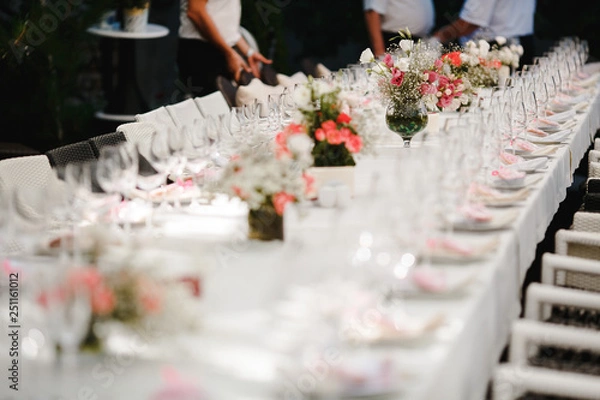 Obraz Bouquets of flowers and crystal dishes decorated on a white table.