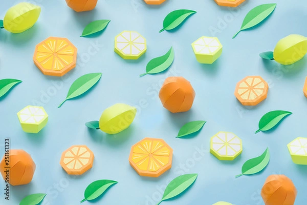 Fototapeta Fruit made of paper. Blue background. There's room for writing. Tropics. Flat lay. Orange, lemon.