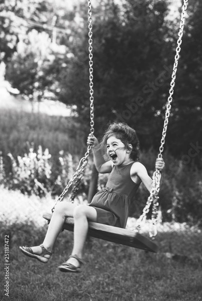 Obraz Black and white portrait of Beautiful little girl smiling on swing at summer day, Happy childhood concept. Soft focused.