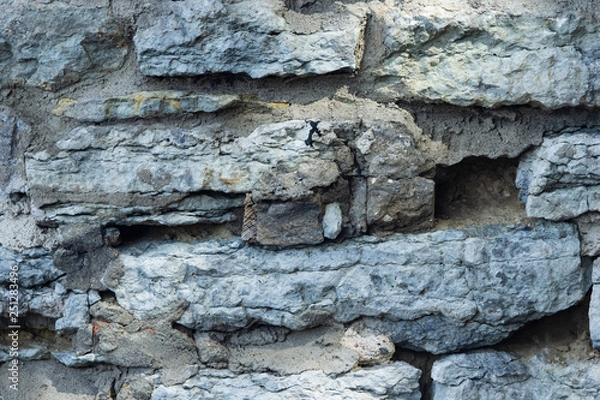 Fototapeta Old grey rough stone wall close-up texture background, selective focus, shallow DOF