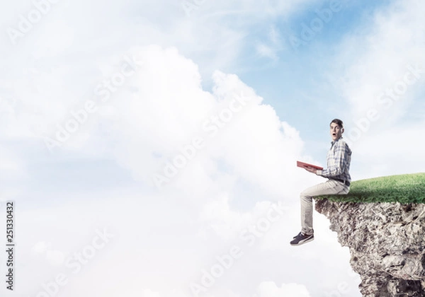 Fototapeta Student guy with book in hands preparing for exam