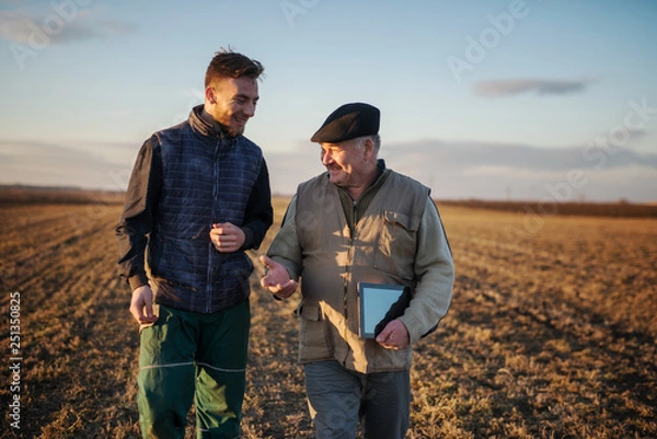 Fototapeta Farmers in the field use advanced technology.