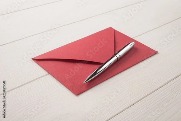 Fototapeta Red envelope and pen on a white background   	 