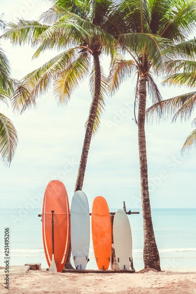Obraz Surfboard and palm tree on beach background.