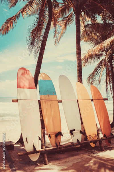 Obraz Surfboard and palm tree on beach background.