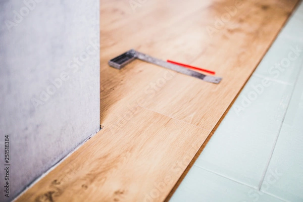 Fototapeta Floor covering - new laminate flooring in the apartment with tools for its installation