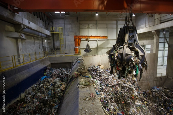 Fototapeta Mechanical claw hand grabbing pile of mixed waste