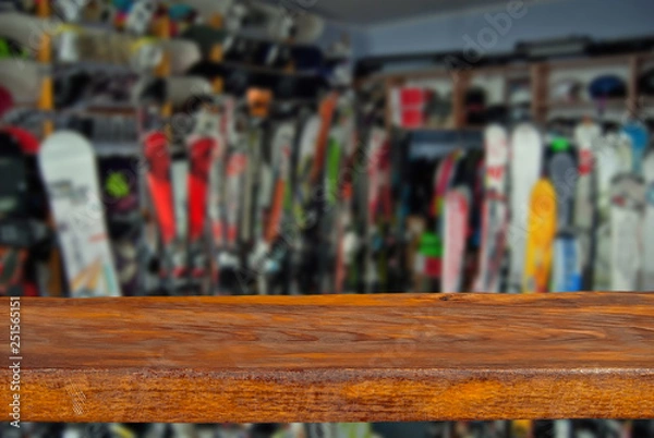 Obraz Mockup. Image of sport store with equipment for skiing. Defocused, blurred image. In the foreground is the top of a wooden table, counter.