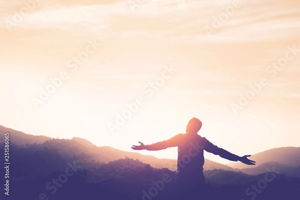 Fototapeta Copy space of man rise hand up on top of mountain and sunset sky abstract background.