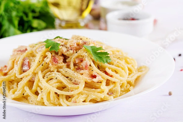 Fototapeta Klasyczny domowy makaron carbonara z pancettą, jajkiem, twardym parmezanem i sosem śmietanowym. Kuchnia włoska. Spaghetti alla Carbonara.