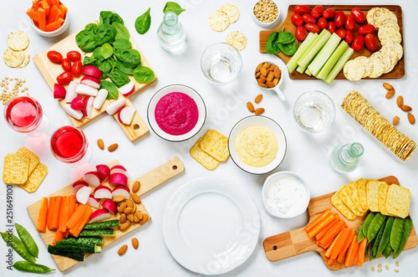 Fototapeta Variation of healthy vegan snacks. Vegetables, crackers, dip and hummus