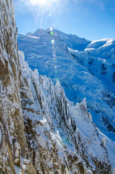 Fototapeta View of the highest european mountain Mont Blanc (at the back in the middle) and french Alps covered with snow. Chamonix-Mont-Blanc during winter time.