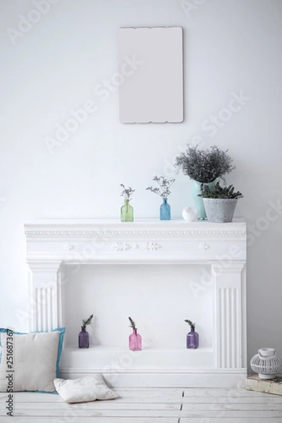 Fototapeta fireplace with decorative ornaments and blank picture on the wall in the living room