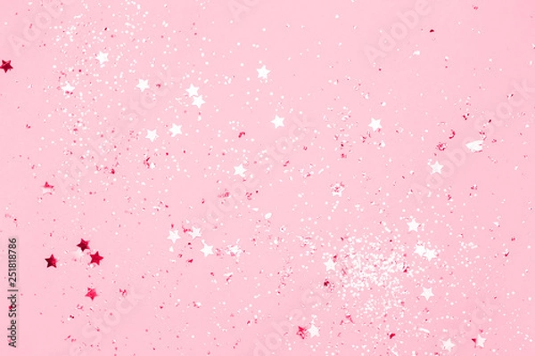 Fototapeta Pink confetti and stars and sparkles on pink background. Top view, flat lay. Copyspace for text. Bright and festive holiday background. For Christmas, New year, Mother's day.