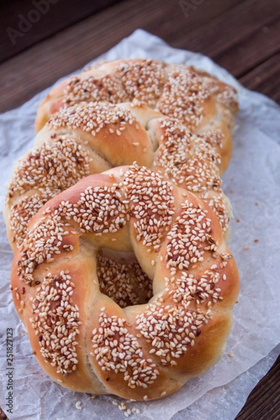 Obraz small Turkish bagels with sesame seeds on baking paper. Simit. close up