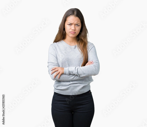Obraz Young beautiful brunette woman wearing sweater over isolated background skeptic and nervous, disapproving expression on face with crossed arms. Negative person.