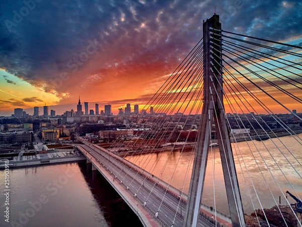 Fototapeta Piękny panoramiczny dron o zachodzie słońca w Warszawie w centrum miasta Warszaw z wieżowcami i mostem SWIETOKRZYSKI (EN: Holy Cross Bridge) - to most startowany przez rzekę Vistula w Warszawie w Polsce