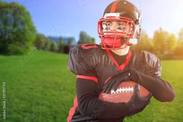 Fototapeta Young american football player in team uniform