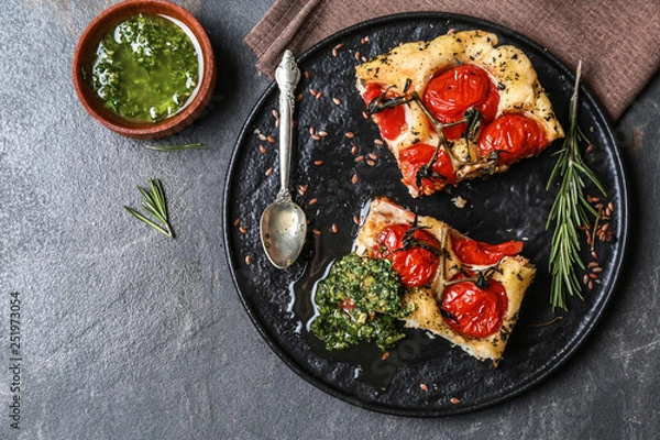 Fototapeta Tasty Italian focaccia and basil sauce on grey table
