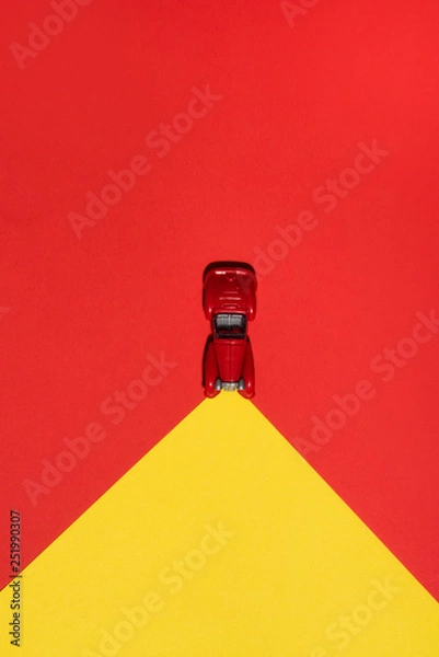 Fototapeta Red car is on red and yellow abstract  background with reflector on the road. Abstract conception.