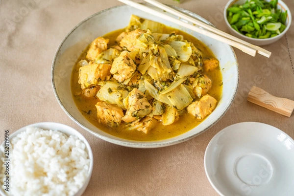 Fototapeta Chicken with cabbage in a curry sauce in a large bowl and a cup of rice, chopsticks - Japanese cuisine
