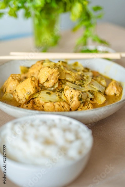 Fototapeta Chicken with cabbage in a curry sauce in a large bowl and a cup of rice, chopsticks - Japanese cuisine