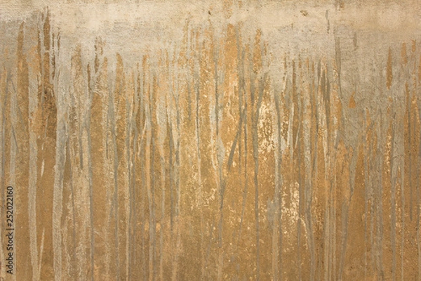 Fototapeta old yellow concrete wall with scratches and gray vertical streams of paint. rough surface texture
