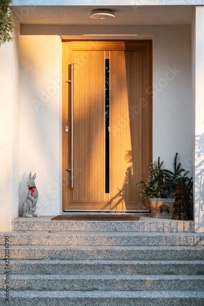 Fototapeta Front door of modern house with Easter Bunny in front for decoration