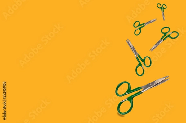 Fototapeta Falling of worn metal scissors on orange background with copy space for your text