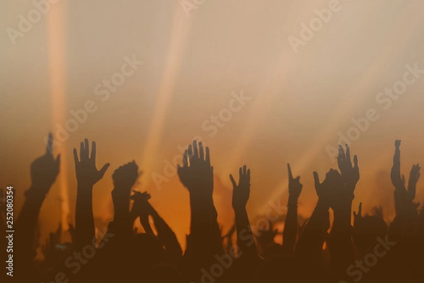 Obraz Hands silhouettes of the crowd raised up at music show. Colorful background