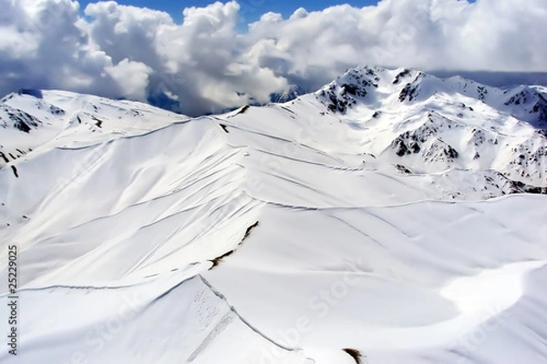 Fototapeta Aerial view of snow-covered mountains